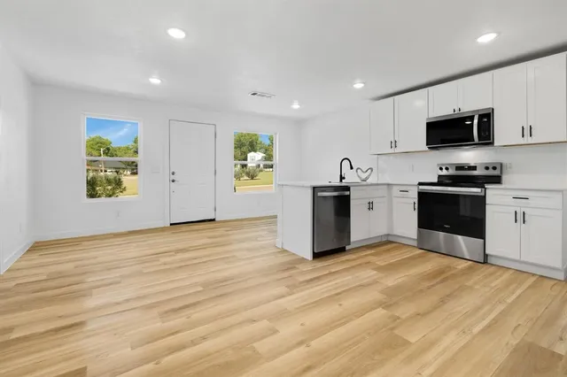 a view of kitchen with microwave stove top oven and refrigerator