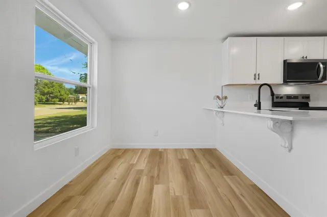 a view of a kitchen with a sink wooden floor and a window