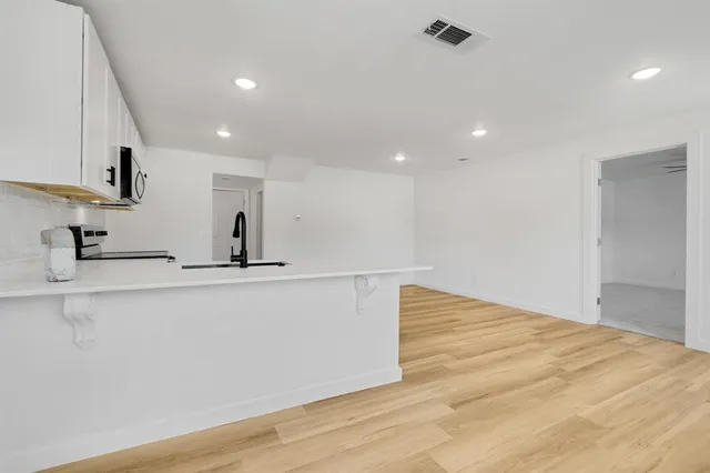 a view of kitchen with stainless steel appliances granite countertop a sink and a refrigerator