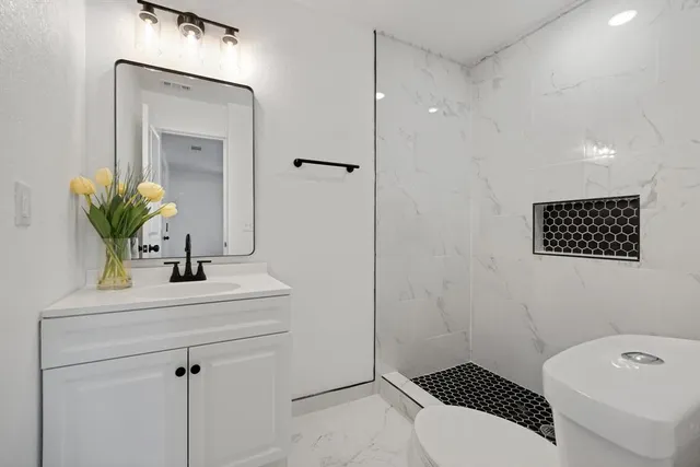 a bathroom with a sink a toilet and shower