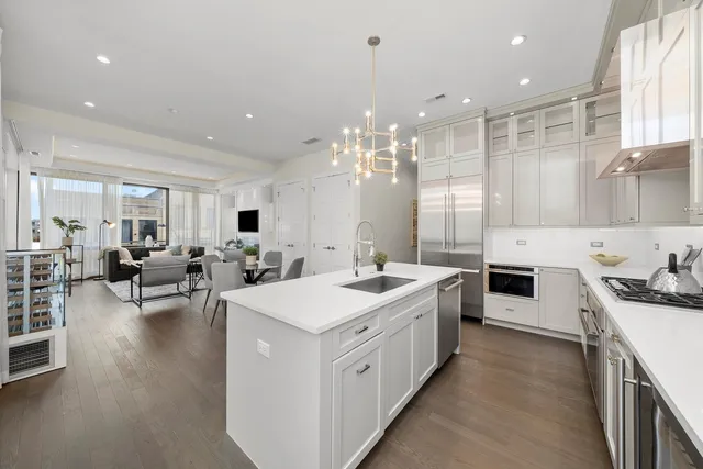 a kitchen with a sink a counter top space stainless steel appliances and cabinets