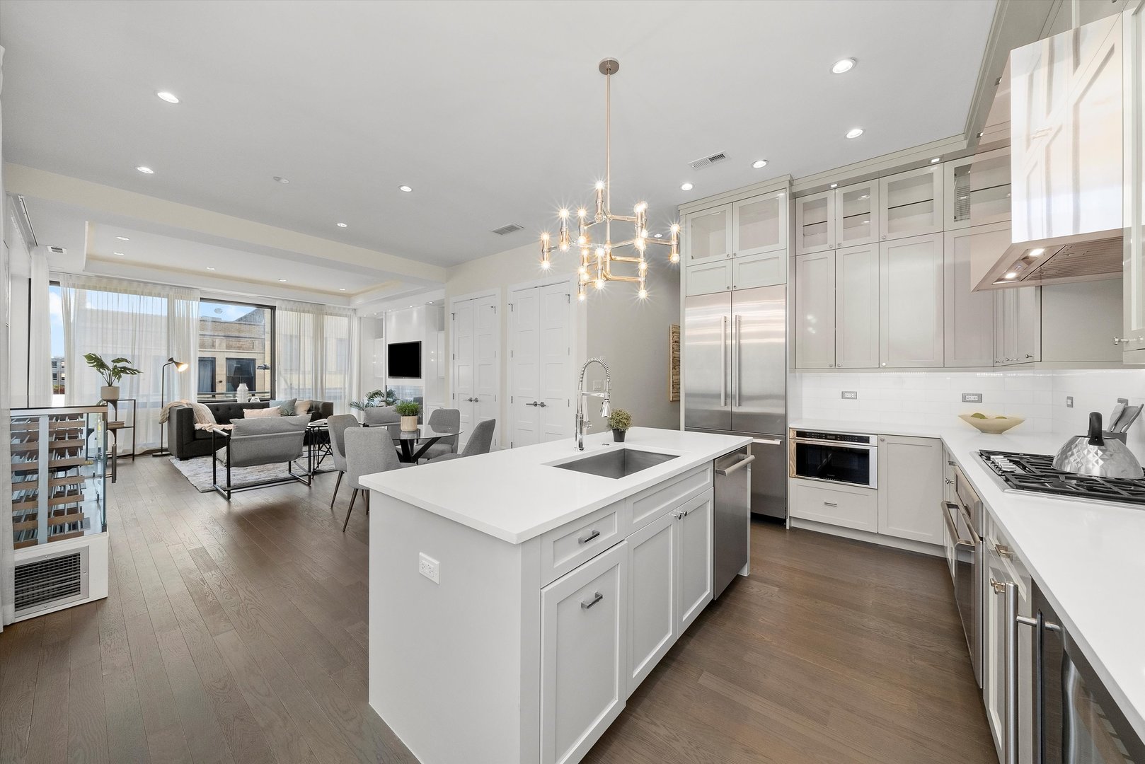 1258 North Milwaukee Avenue, Unit 3N Chicago, IL 60622 - Photo 3 of 36 a large white kitchen with a large counter top space a sink stainless steel appliances and cabinets