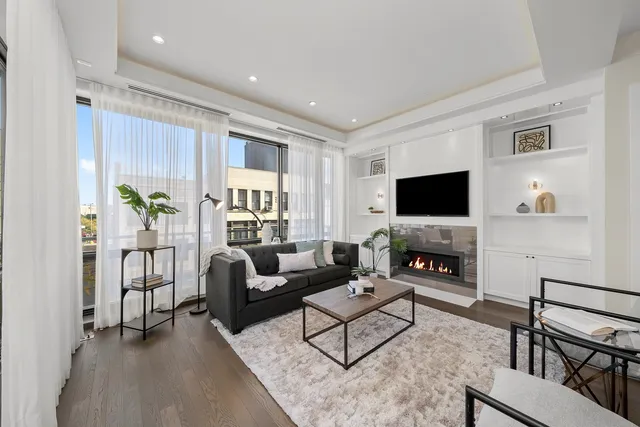a living room with furniture a flat screen tv and a fireplace
