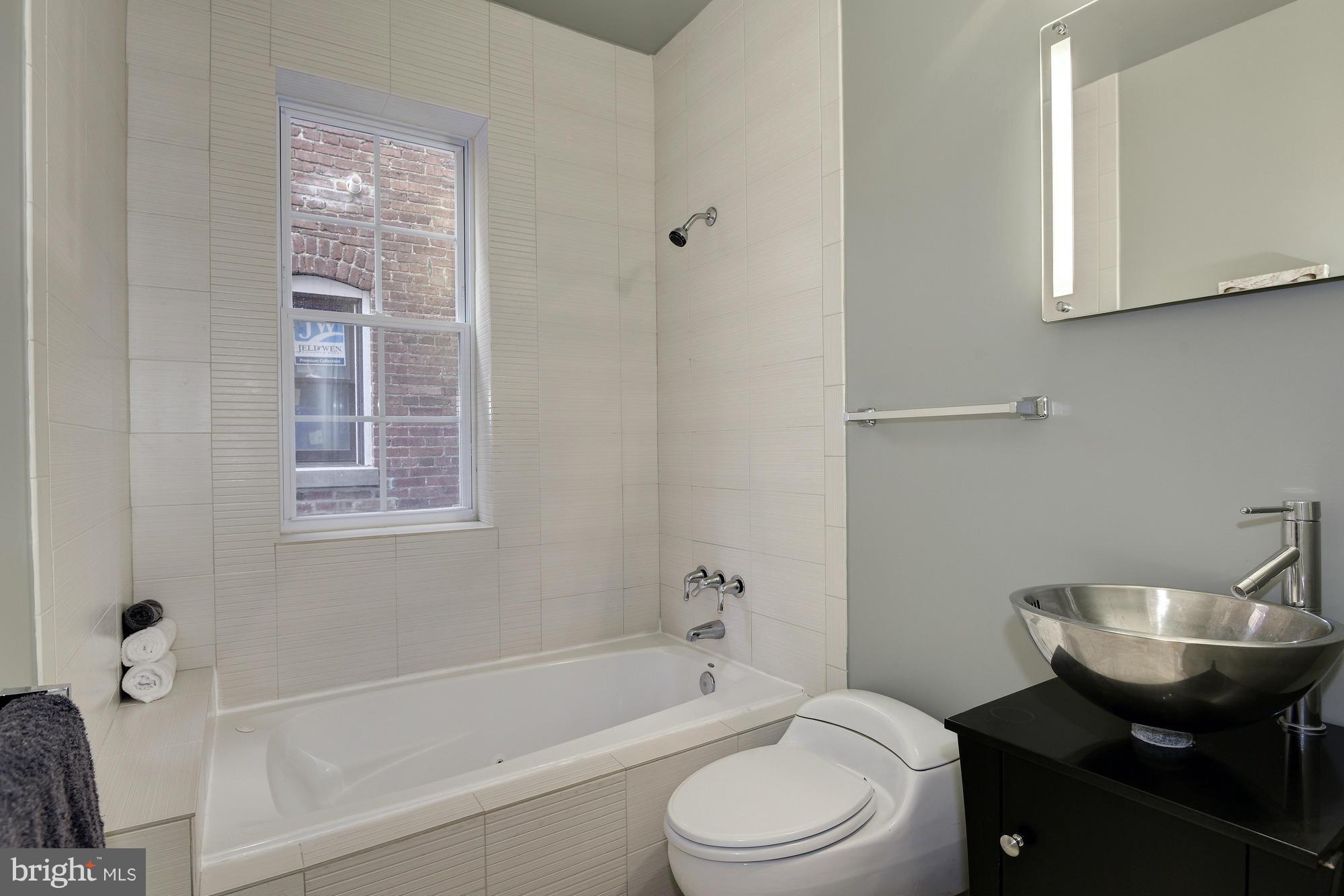 1126 Columbia Road Northwest, Unit 3 Washington, DC 20009 - Photo 14 of 23 a bathroom with a sink toilet a mirror and shower