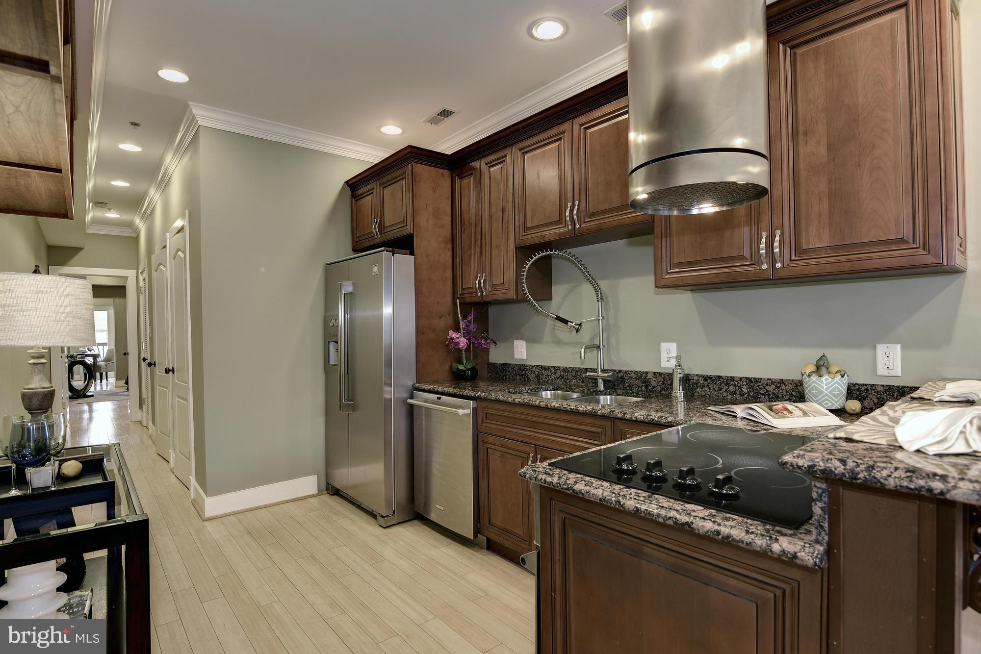 1126 Columbia Road Northwest, Unit 3 Washington, DC 20009 - Photo 7 of 23 a kitchen with granite countertop stainless steel appliances and wooden cabinets