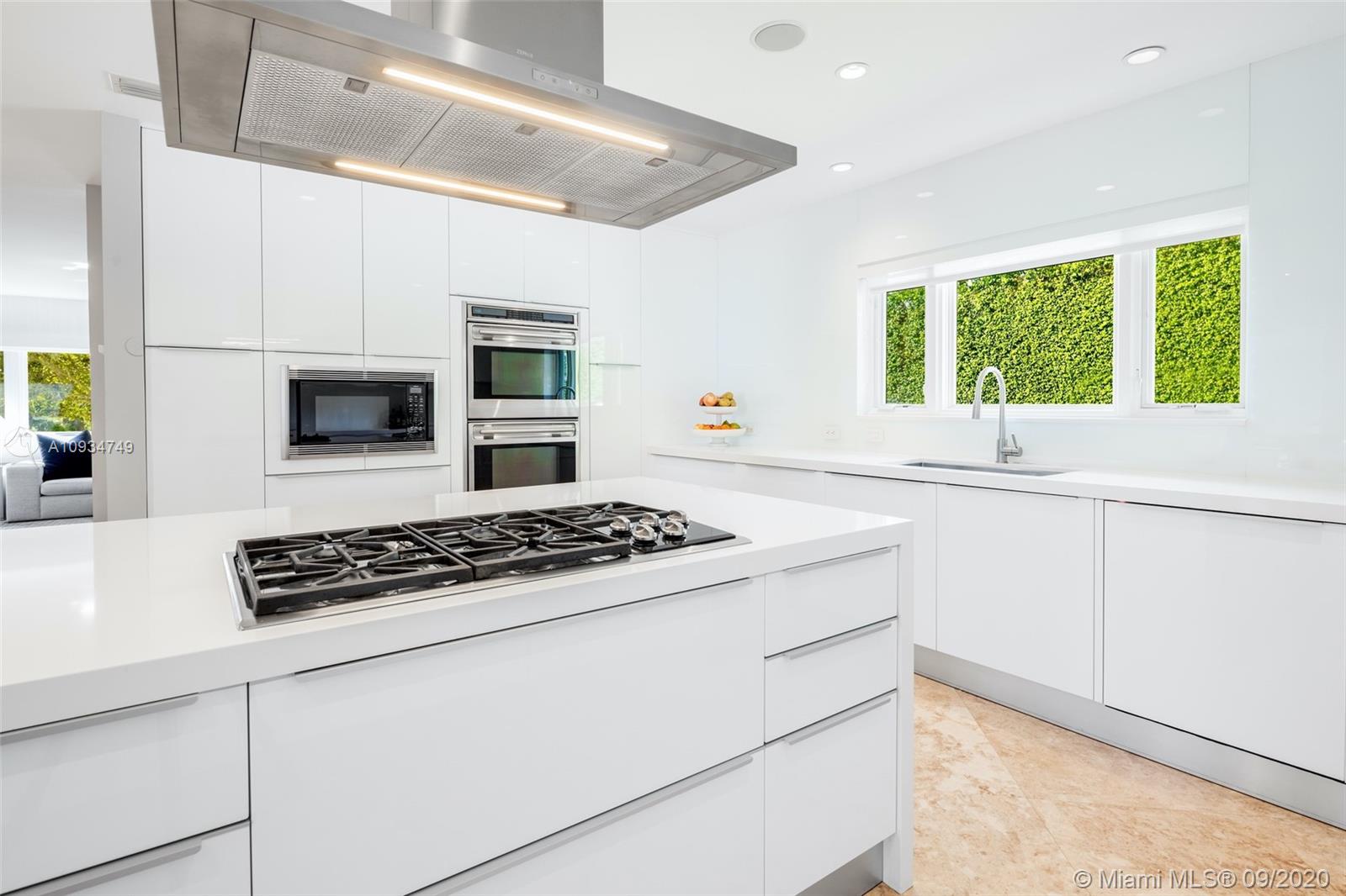 4301 Bay Point Road Miami, FL 33137 - Photo 15 of 33 a kitchen with white cabinets and appliances