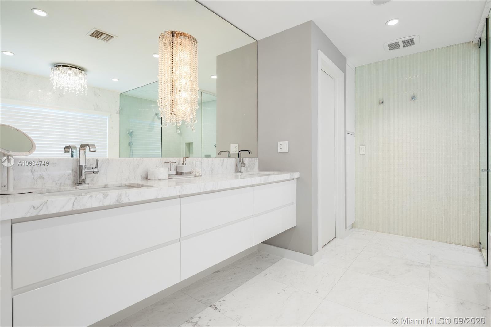 4301 Bay Point Road Miami, FL 33137 - Photo 19 of 33 a bathroom with a double vanity sink and a mirror