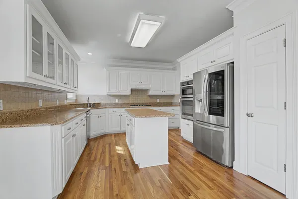 a kitchen with white cabinets and stainless steel appliances