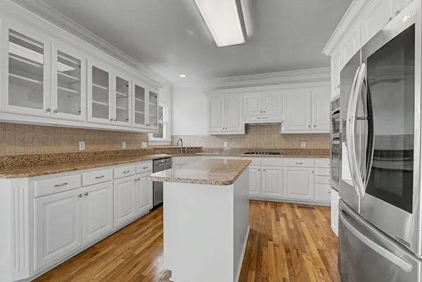 a kitchen with granite countertop white cabinets and stainless steel appliances