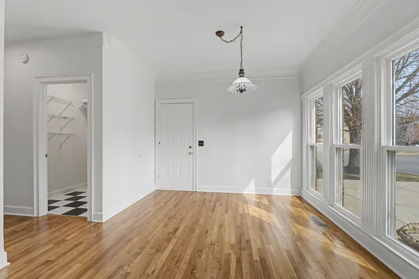 a view of empty room with wooden floor