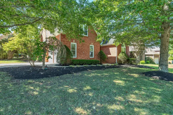 a front view of house with yard and green space