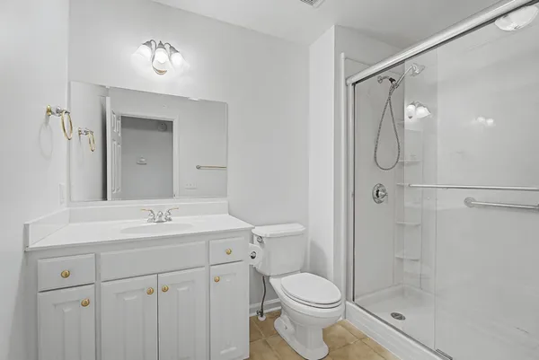 a bathroom with a shower sink vanity mirror and toilet