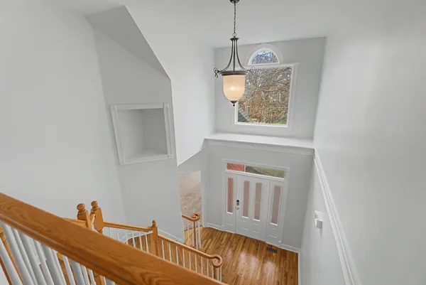 a view of a livingroom with furniture wooden floor windows and a chandelier