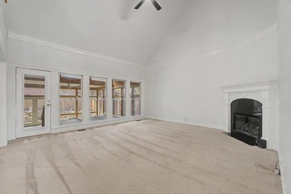 a view of an empty room with a fireplace and a window