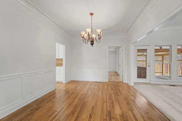 a view of empty room with wooden floor and window