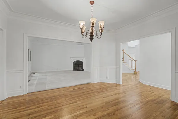 a view of a room with wooden floor and chandelier