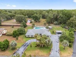an aerial view of a house with a yard basket ball court and outdoor seating