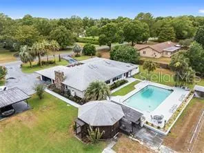 an aerial view of a house with swimming pool garden and outdoor seating