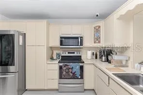 a kitchen with white cabinets and sink