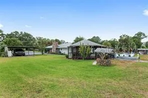 a view of a house with backyard and sitting area