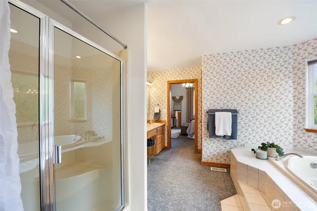 a en suite bathroom with a granite countertop sink a mirror and shower