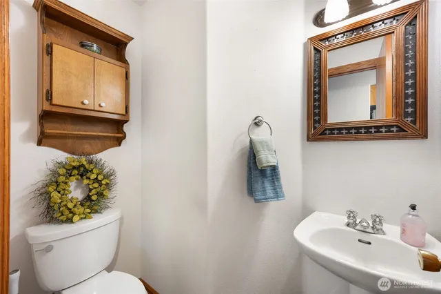 a bathroom with a toilet sink and mirror