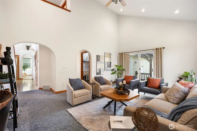 a living room with furniture a rug potted plant and a large window