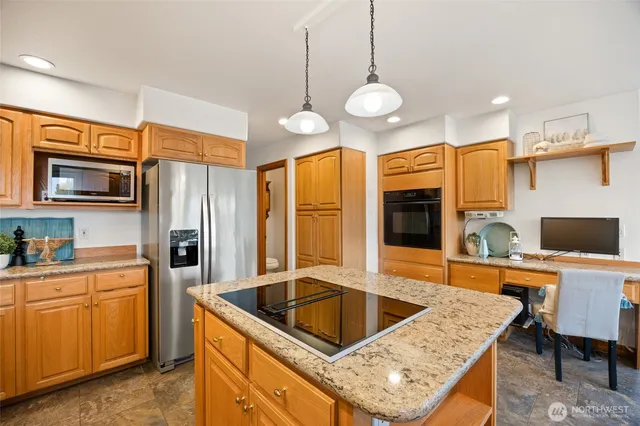 a kitchen with stainless steel appliances granite countertop a sink a stove and a refrigerator