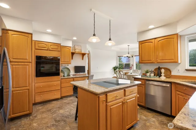 a kitchen with granite countertop a sink stainless steel appliances and cabinets