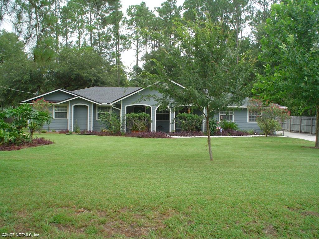 a house with a big yard and large trees
