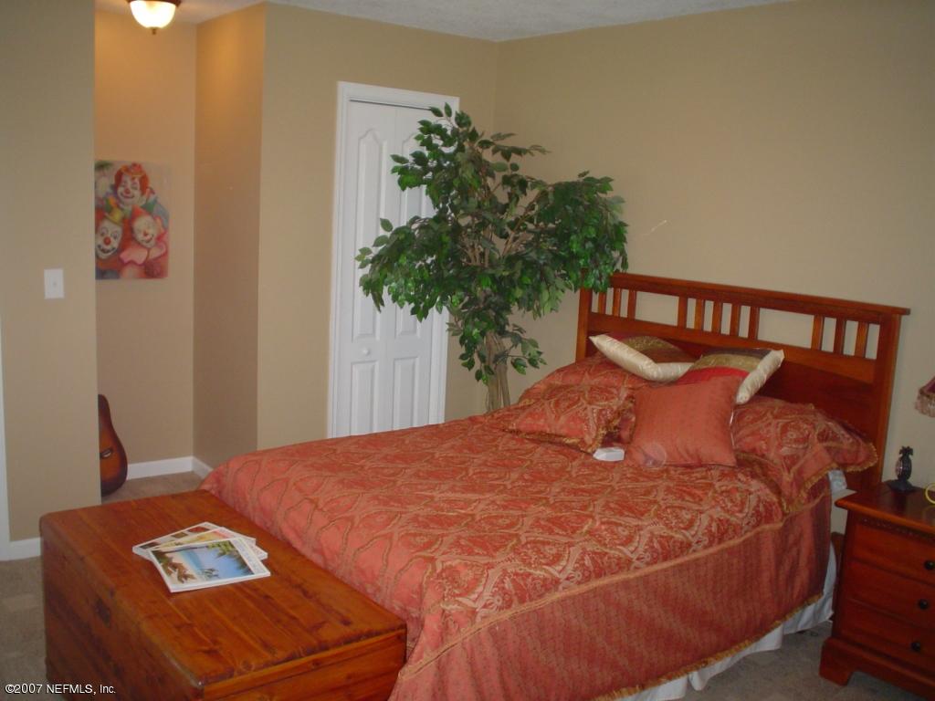 1497 Satsuma Road Jacksonville, FL 32259 - Photo 8 of 9 a large bed sitting in a bedroom next to a window