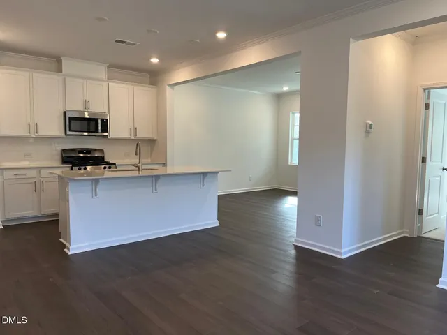 a kitchen with stainless steel appliances granite countertop a sink a stove and a refrigerator
