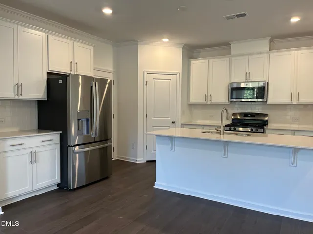 a kitchen with stainless steel appliances a refrigerator sink and microwave