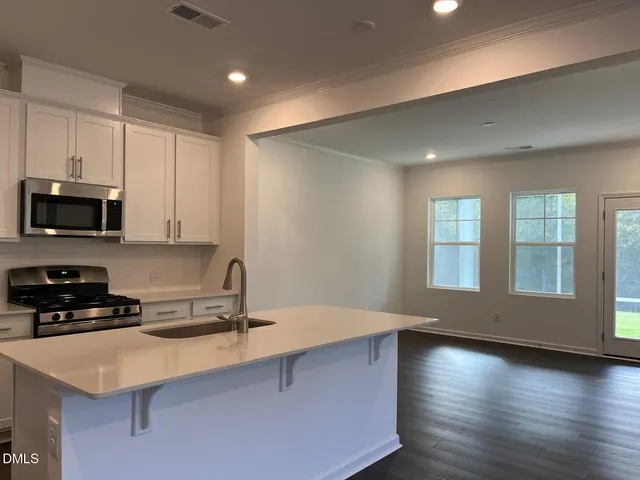 a kitchen with stainless steel appliances a sink a stove a microwave and cabinets
