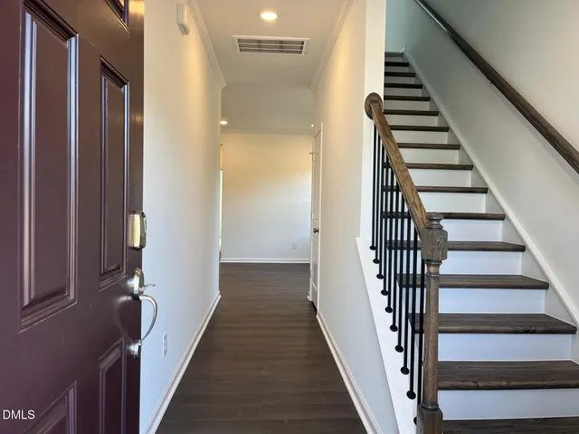 a view of a hallway with wooden floor and entryway