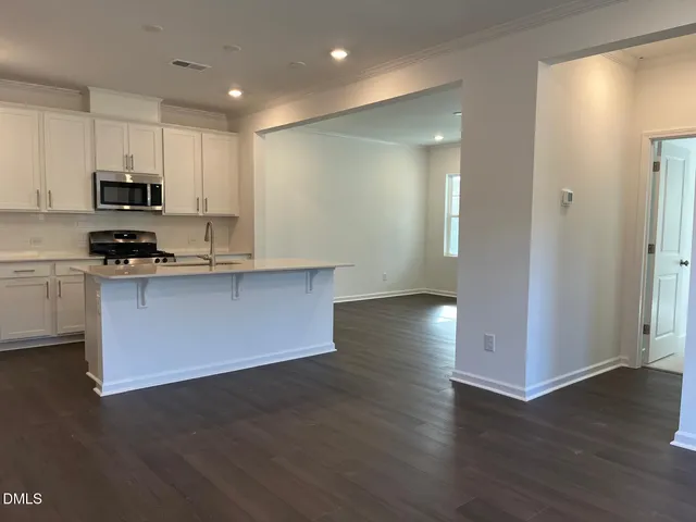 a kitchen with stainless steel appliances granite countertop a sink a stove a refrigerator and cabinets