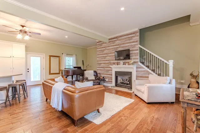 a living room with fireplace furniture and a wooden floor