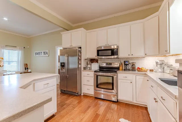 a kitchen with white cabinets and stainless steel appliances