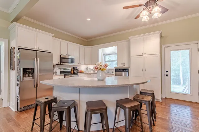 a kitchen with stainless steel appliances a dining table and chairs