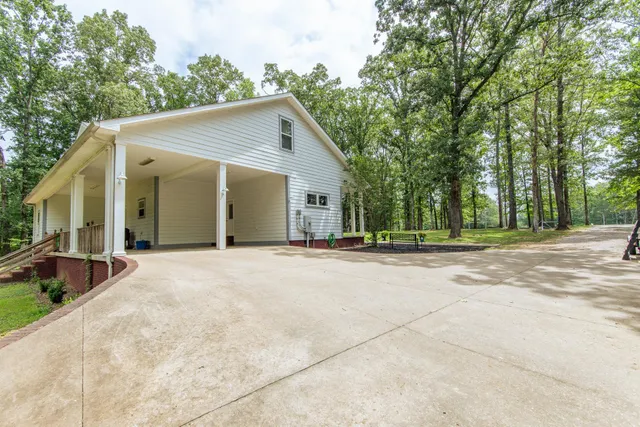 a view of a house with backyard and trees
