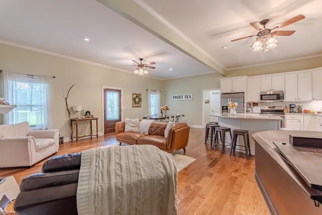 a large room with stainless steel appliances lots of white furniture a dining table and chairs