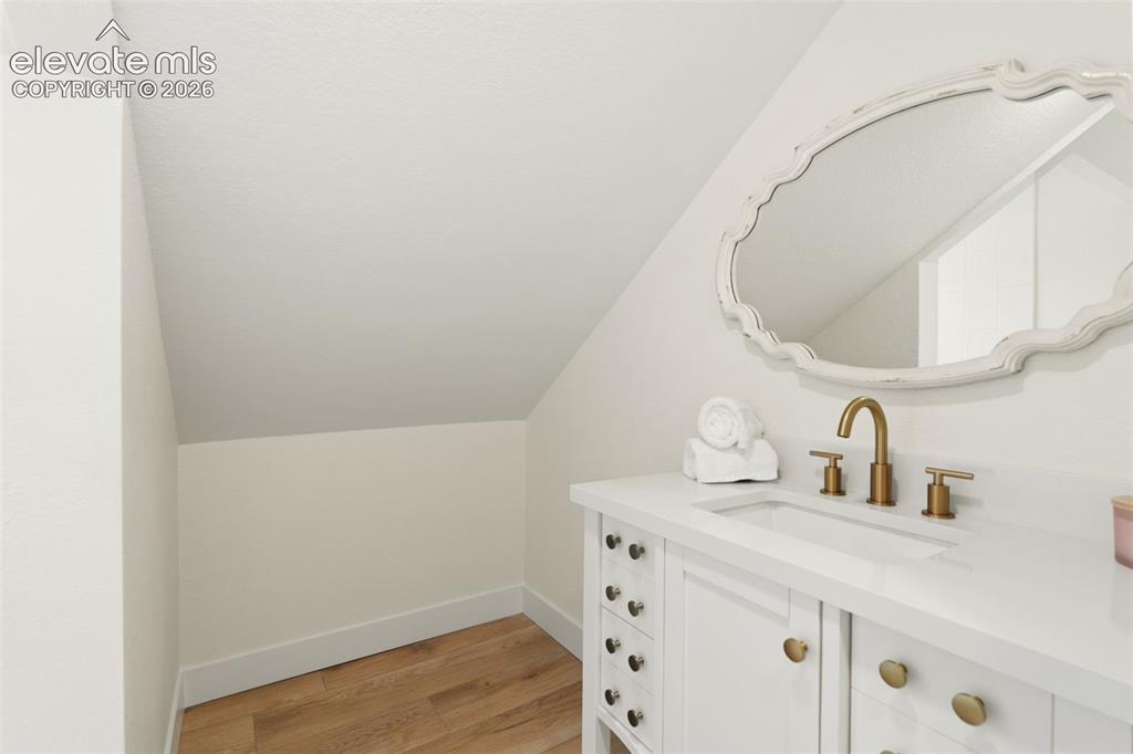 11665 Greentree Road Colorado Springs, CO 80908 - Photo 28 of 43 Bathroom featuring vanity, light wood-style floors, and vaulted ceiling