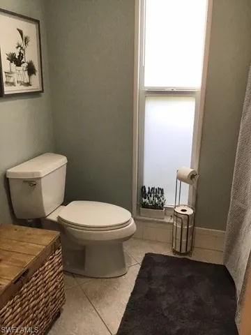 a white toilet sitting next to a bathroom sink and a mirror