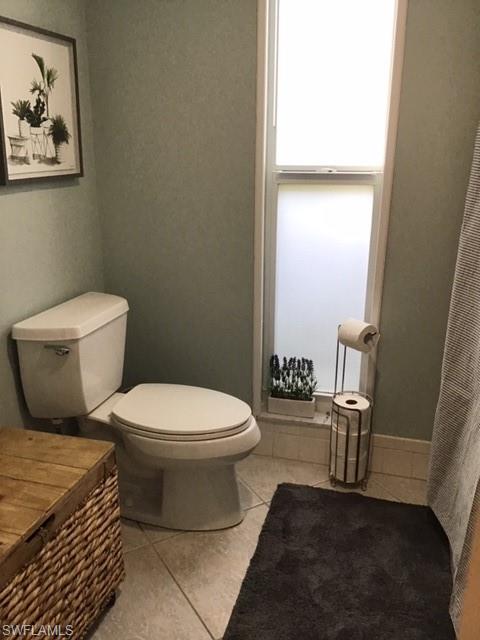 195 Peppermint Lane, Unit 881 Naples, FL 34112 - Photo 12 of 35 a white toilet sitting next to a bathroom sink and a mirror