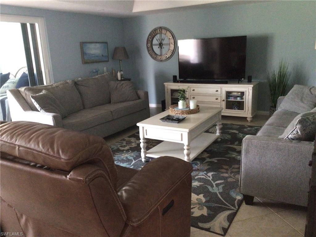 195 Peppermint Lane, Unit 881 Naples, FL 34112 - Photo 7 of 35 a living room with furniture a flat screen tv and a window