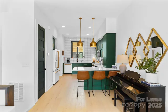 a kitchen with stainless steel appliances kitchen island granite countertop a refrigerator and a sink