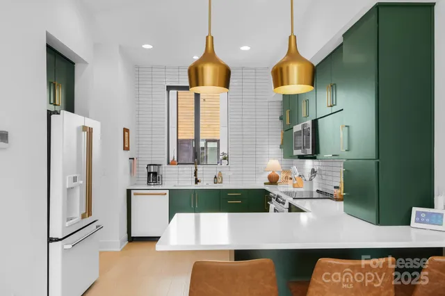 a kitchen with stainless steel appliances kitchen island granite countertop a refrigerator a stove and a sink