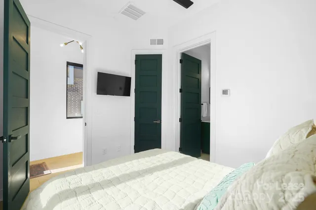 a bedroom with a bed and a flat screen tv