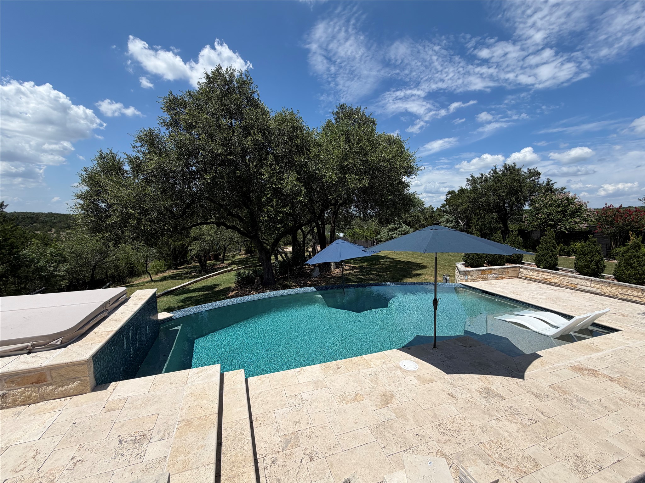 7801 Aria Loop Austin, TX 78736 - Photo 2 of 40 Picturesque Covered Patio with Negative Edge Pool overlooks the gently rolling, terraced Back Yard which is a perfect space to play and entertain