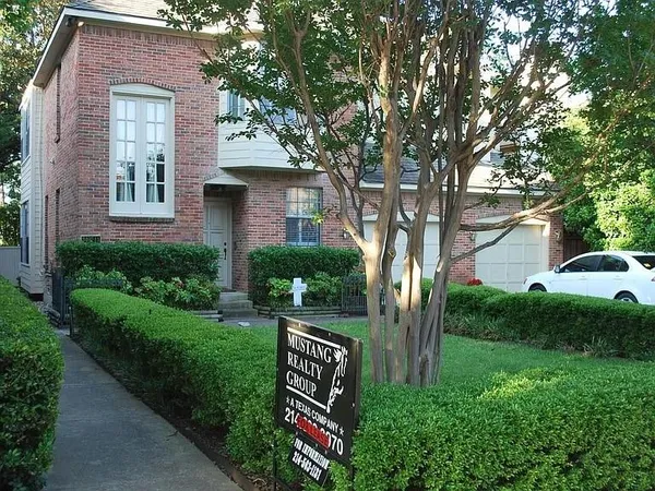 a front view of a house with a yard and tree